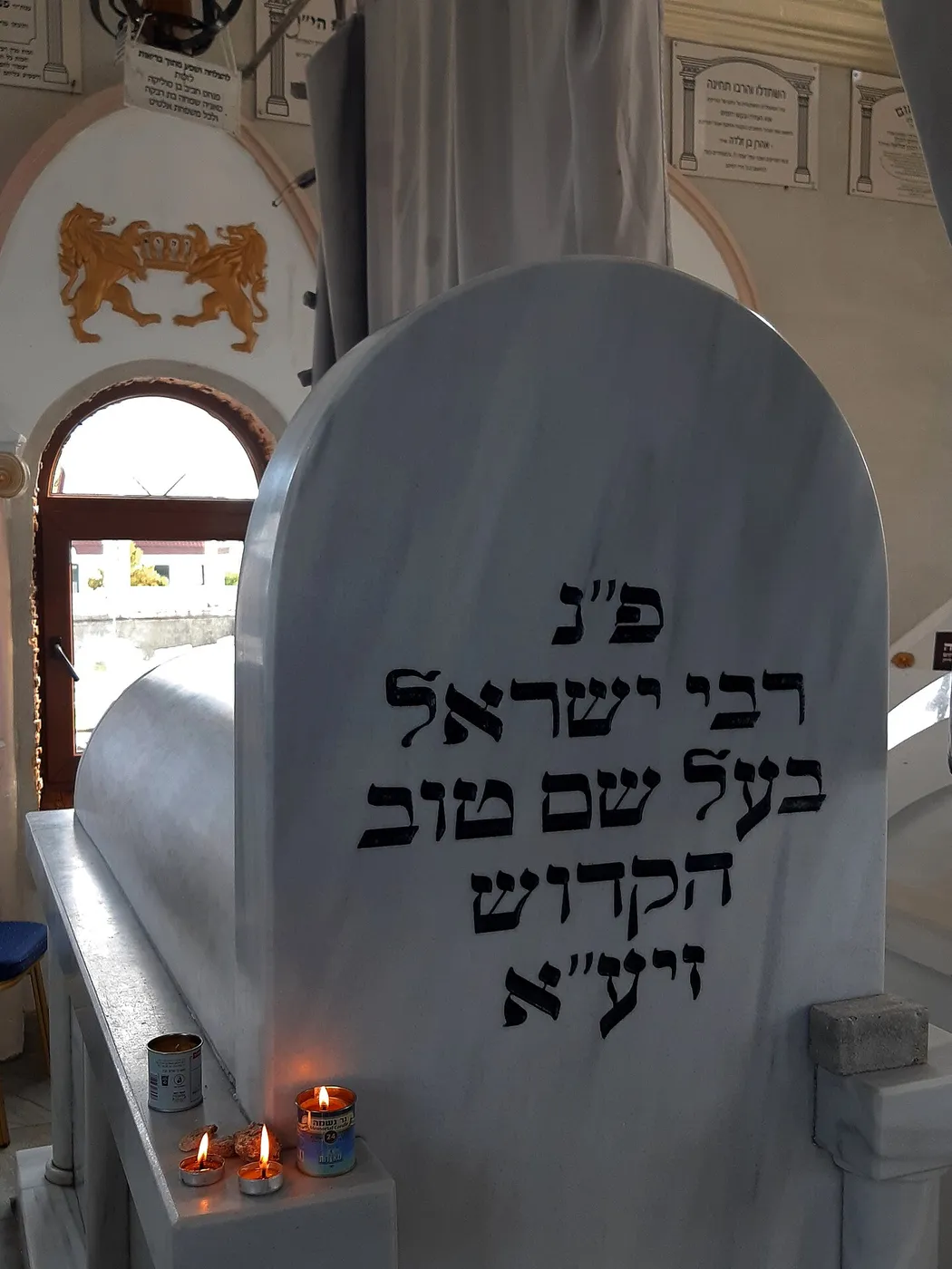 מצבת קבר רבי ישראל בעל שם טוב בתוך האוהל במז׳יבוז׳, ולידה נרות דולקים
