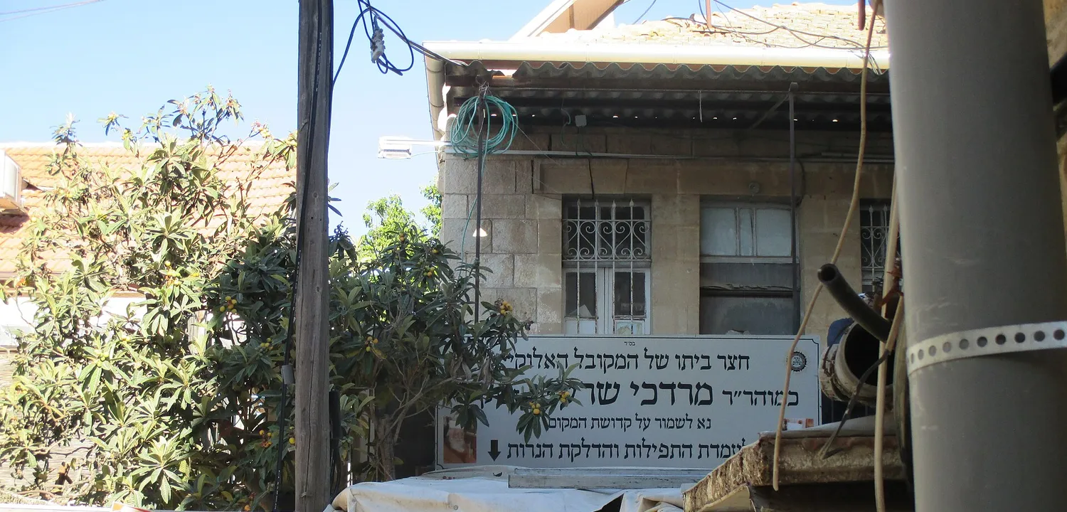 שלט בחצר ביתו של רבי מרדכי שרעבי בנחלאות, מקום לאמירת תפילות ולהדלקת נרות